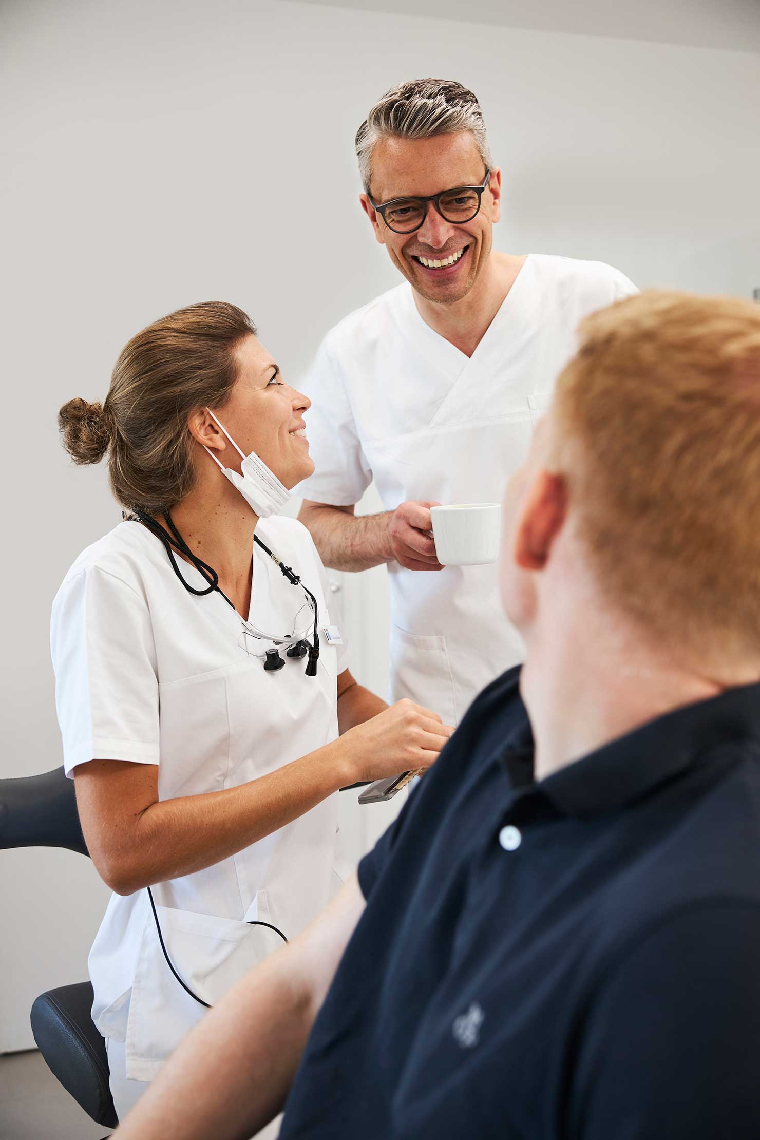 Zahnärzte unterhalten sich mit dem Patienten